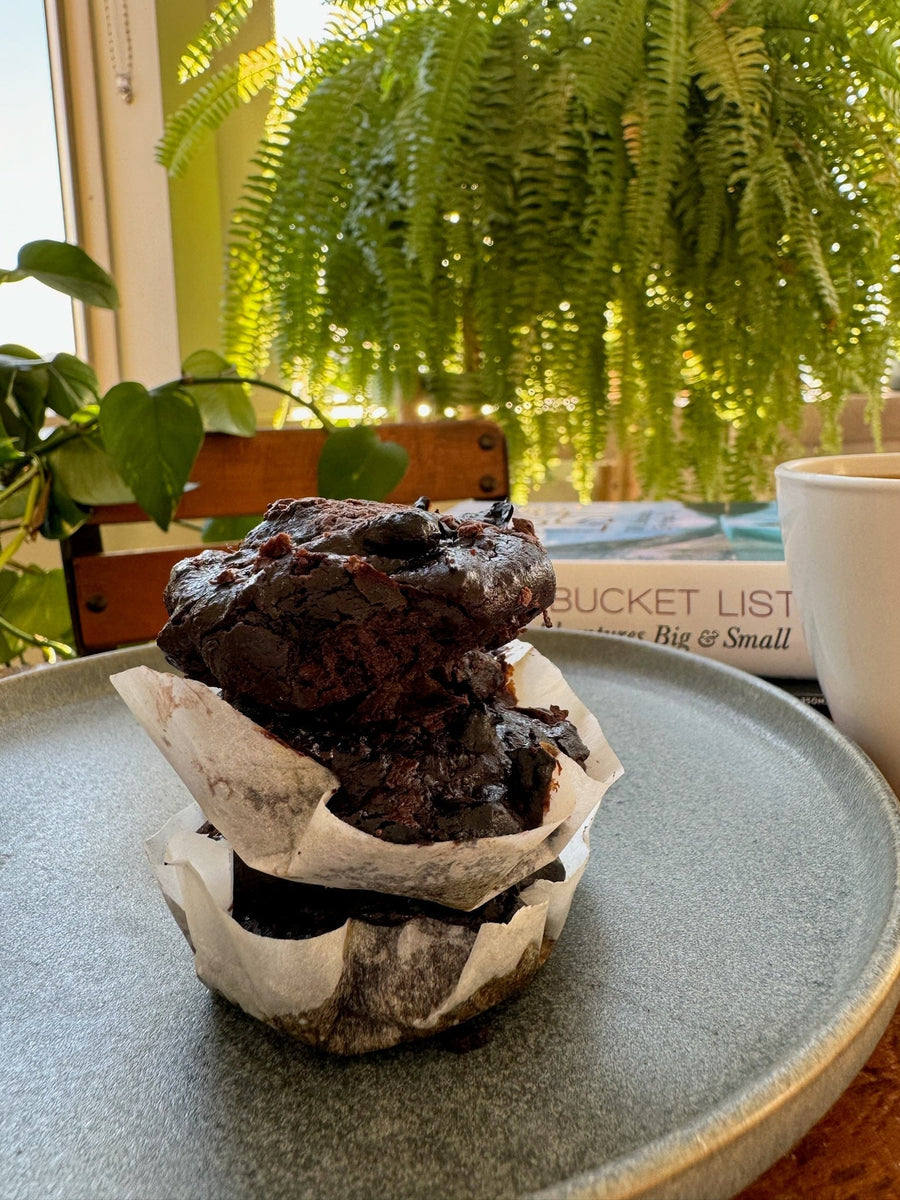 Sugar-free pistachio butter brownies stacked on parchment paper on a plate
