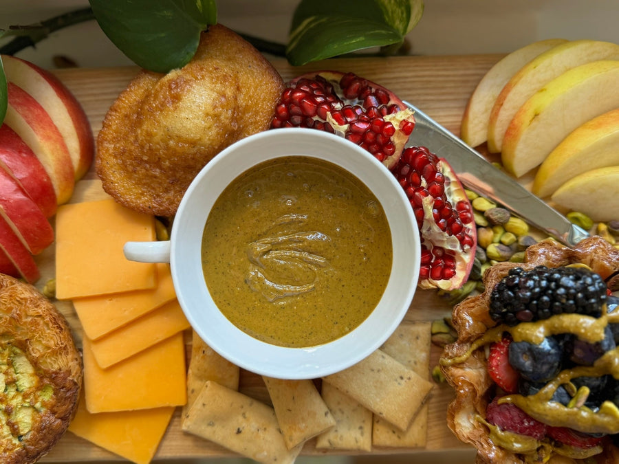 Pistachio butter dip served with apples, crackers, cheese, and fruit on a charcuterie-style board