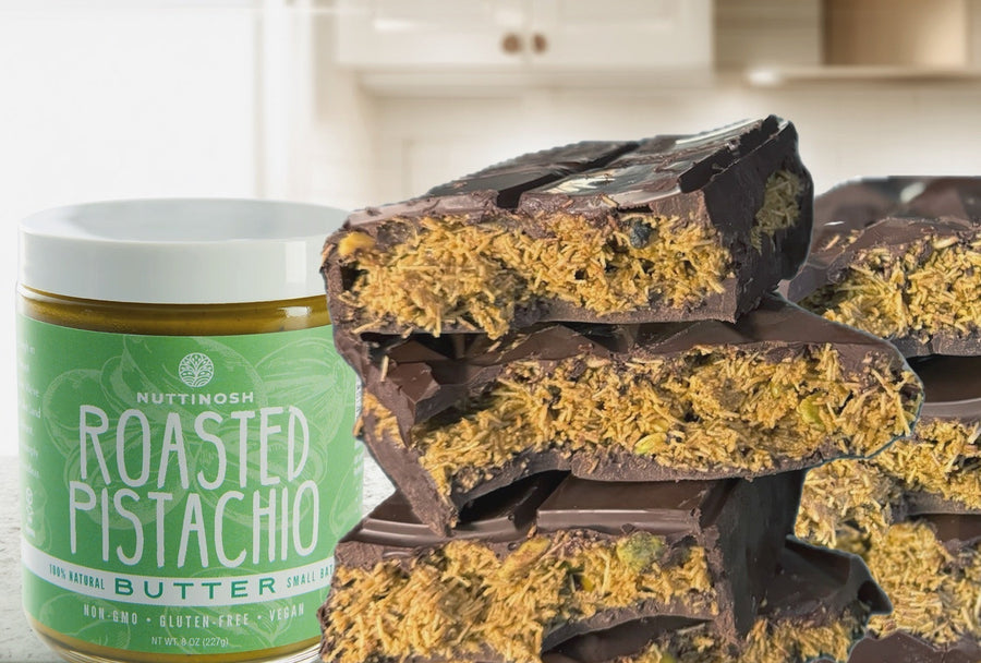 Nuttinosh roasted pistachio butter jar next to stacked chocolate pistachio dessert bars