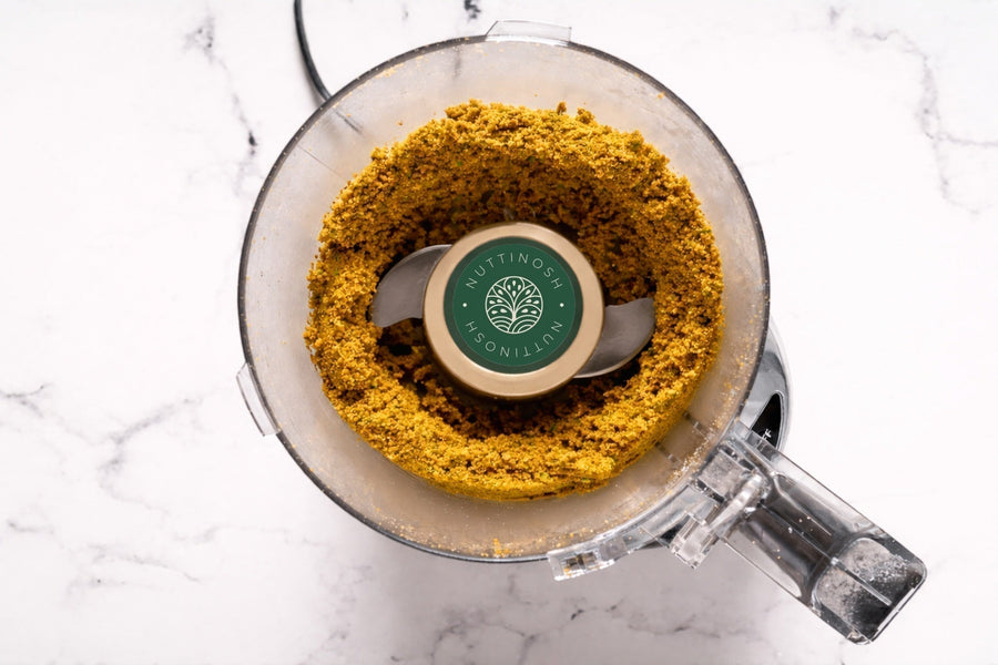 Food processor with ground pistachios used to make pistachio butter
