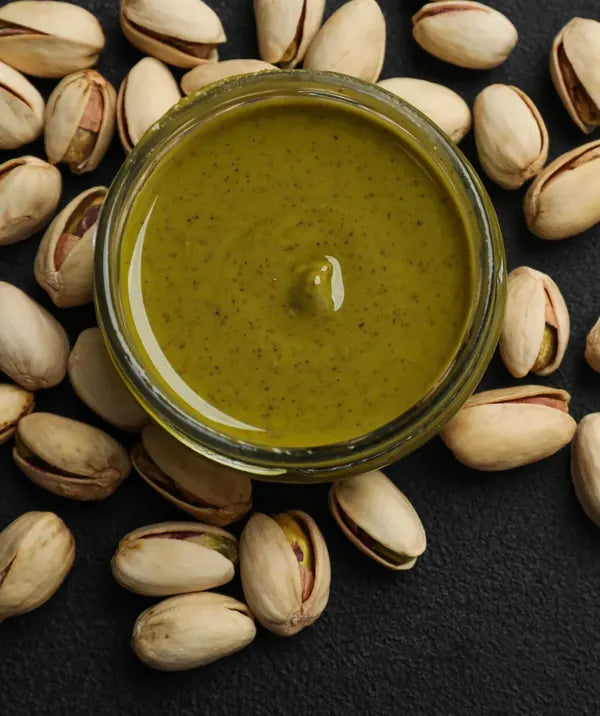 Nuttinosh pistachio butter surrounded by shelled pistachios