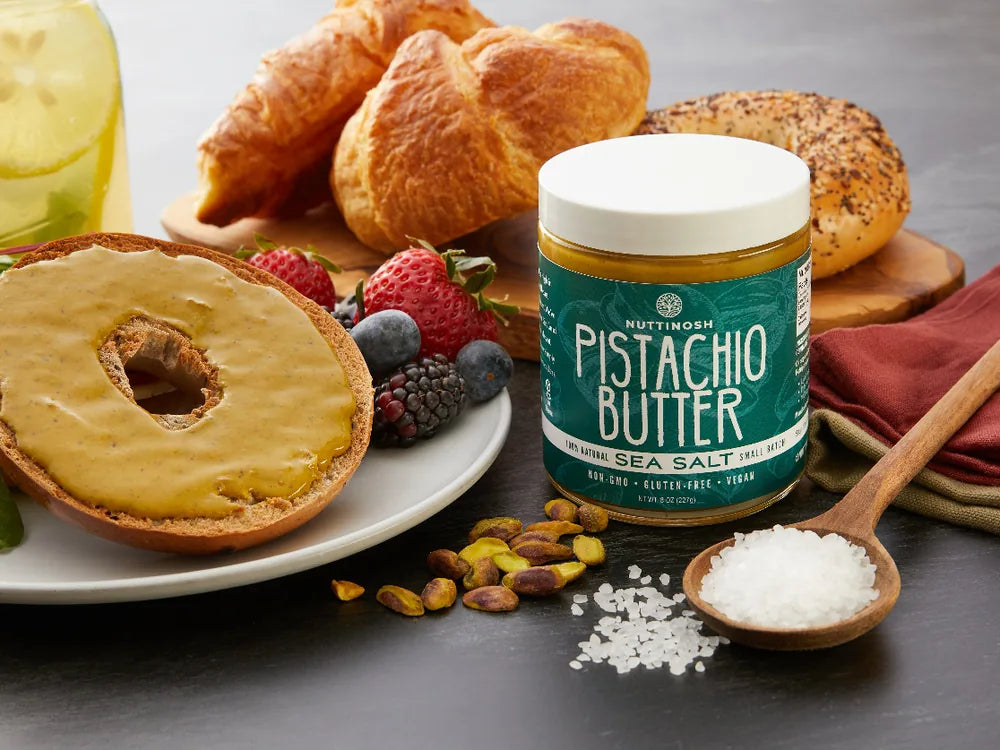 Nuttinosh sea salt pistachio butter with bagel, croissants, pistachios, and breakfast spread